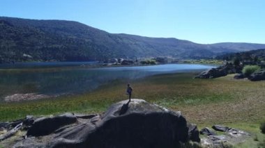 Hava dron sahne Pulmari Gölü rock Island, ağaçlar, mavi gökyüzü, bozkır ve gölde bir taşın isteyen birisi. Kamera hareketli ileriye.