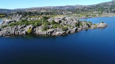 Hava üst Pulmari Gölü, Neuquen, Patagonia, Arjantin dron sahne Rock Island ağaçları ile görüntüleyin. Güneşli bir sonbahar içinde gezinmek kamera. Güneşin suya yansıyan.