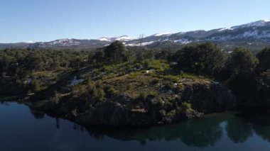 Alumine Gölü, Villa Pehuenia, Moquehue, Neuquen, Patagonya Arjantin hava dron sahne. Güzel manzara ile Batea Mahuida volkan ve Dağları kar ile keşfetmek bir ada üzerinde geçen kamera.