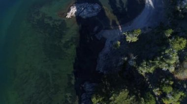 Hava senital dron sahne Alumine sahil. Üstten görünüm kayalık Beach, sarı kavak. Kamera yavaş yavaş terk edilmiş bir ev kıyı boyunca hareket eder. Mapuçe alan turistik bölge beş lagün villa pehuenia içinde