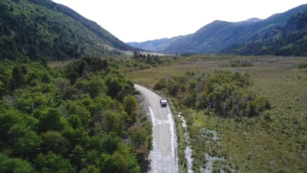 Drone Scène d'un chemin de terre humide avec un van avec un camping-car par une journée ensoleillée à l'automne et la steppe avec des arbres verts, Neuquen, Moquehue, Patagonie, Argentine 