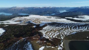 Villa Pehuenia karlı Batea Mahuida volkan hava dron sahne. Kamera lagün üzerinde seyahat ileri geçen Nothofagus tarafından ormanlar ve karlı yamaç. Arka plan Gölü Alumine ve Moquehue Neuquen, Patagonya Arjantin.