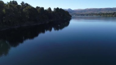 Araucaria woods ile hava dron sahne Alumine Gölü, batea mahuida ve dağlar. Kamera göl üzerinde alçak irtifada başlar ve ileriye daha yüksek bakış açısı, neuquen, patagonia için yükselir