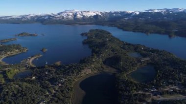Bir yarımada ile hava dron sahne Villa Pehuenia şehirde, Moquehue, Neuquen, Patagonya Arjantin ev sahipliği yapmaktadır. Bazı adalar Alumine göle doğru ilerlemeye kamera. Dağları kar ile