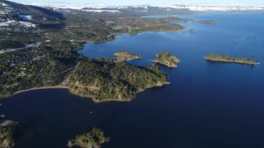 Villa Pehuenia Town, Moquehue, Neuquen, Patagonya Arjantin hava dron sahne. Bazı adalar Alumine göle doğru ilerlemeye kamera. Arka planda kar ile Dağları.