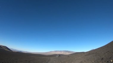 Geriye doğru gidiyor, La Payunia Milli parkta, Malarge fotoğraf makinesinin stabilize kamera hareketi. Siyah ve kırmızı dağlar ve volkanlar lapillis volkanik kayalar altın otlar ile yapılmış. Araba Park.