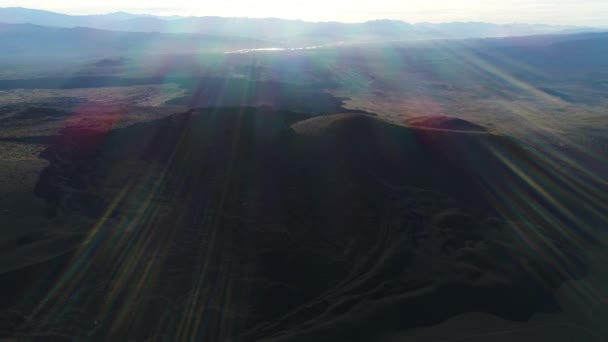Malarge メンドーサ アルゼンチンのラ Payunia 国立公園で溶岩の暗い黒いベッドの空中ドローン シーン カメラは 日没の黄金時間に後方に移動します レンズ フレア — ストック動画