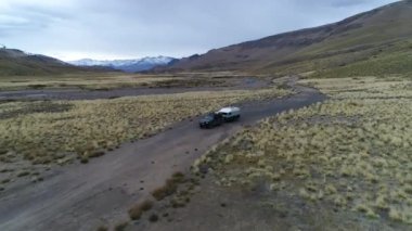 Andes Dağları, Mendoza, Arjantin hava dron sahne. Patagonya bozkır. Kamera geriye doğru gidiyor. Yalnız yol Van römork, kamyonet ve karavan ile izleme. Campanario dağın karla.