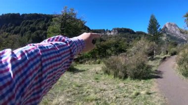 Dağ orman, ahşap ve şelale. Adam el ile şelale konumunu işaret eder. Lanin Milli Parkı. Paimun Gölü'nün çevresi. Neuquen, Patagonia, Arjantin