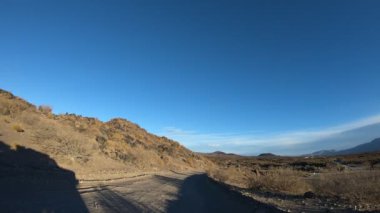 Çakıl yol çok rüzgarlı bir günde Timelapse. Mendoza Cuyo, Arjantin. Kamera hareketli ileri. Yağ extravtion pompaları iki tarafta. Bulutlar gökyüzü üzerinde.