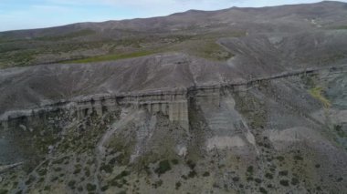 Kaya oluşumları ile kale, evler silhuette. Castillos de Pincheira turistik yer. Hava sahne boyunca jeolojik oluşumlar. Yüksek irtifada yana doğru gidiyor. Patagonia, Malarge