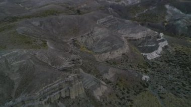 Kaya oluşumları ile kale, evler silhuette. Castillos de Pincheira turistik yer. Önden görünüm sahne azalan için hava. Arka plan dağlar ve jeolojik oluşumlar. Patagonia, Malarge
