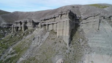 Kaya oluşumları ile kale, evler silhuette. Castillos de Pincheira turistik yer. Hava sahne boyunca jeolojik oluşumlar. Yana doğru ve kayaların çevresinde olacak. Patagonia, Malarge, Mendoza