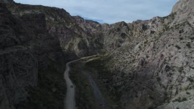 Atuel river canyon San Rafael, Mendoza Cuyo Arjantin hava dron sahne. Hareketli kamera modern yeni 4 x 4 van izleme iletir. Çakıl sokak sonraki ağaçlar ve nehir. Derma kayalar.