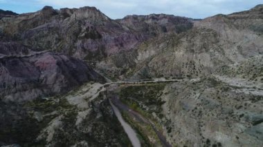 Atuel river canyon San Rafael, Mendoza Cuyo Arjantin hava dron sahne. Yukarı doğru hareket kamera ve modern yeni 4 x 4 van görünür. Çakıl sokak sonraki ağaçlar ve nehir. Derma kayalar.