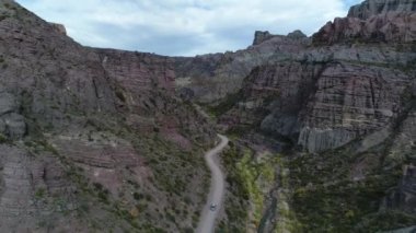 Atuel river canyon San Rafael, Mendoza Cuyo Arjantin hava dron sahne. Hareketli kamera modern yeni 4 x 4 van izleme iletir. Çakıl sokak sonraki ağaçlar ve nehir. Derma kayalar.