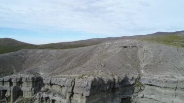 Kaya oluşumları ile kale, evler silhuette. Castillos de Pincheira turistik yer. Hava sahne jeolojik oluşumlar geriye doğru gidiyor. Patagonia, Malarge, Mendoza, Arjantin