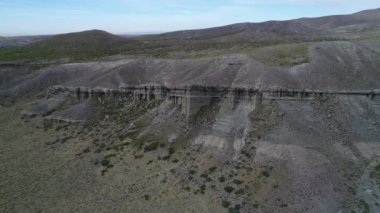 Kaya oluşumları ile kale, evler silhuette. Castillos de Pincheira turistik yer. Hava sahne boyunca jeolojik oluşumlar. Doğru yüksek irtifada gidiyor. Patagonia, Malarge