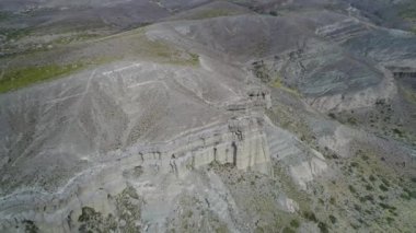 Kaya oluşumları ile kale, evler silhuette. Castillos de Pincheira turistik yer. Önden görünüm sahne azalan için hava. Arka plan dağlar ve jeolojik oluşumlar. Patagonia, Malarge