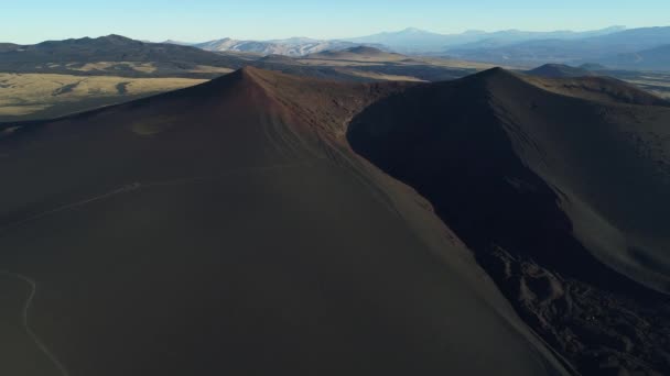 空中无人机场景的黑色破碎火山口与熔岩床在 Payunia 国家公园 Malargue 门多萨 相机侧身移动 在山坡上的路径 背景的安第斯山脉山脉 — 图库视频影像
