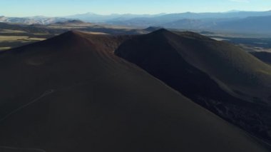 Lav la payunia Ulusal Park, Malargue, mendoza Oda hava dron sahne siyah kırık yanardağ krater. Yana doğru hareket kamera. Yolu dağ yamacında. Belgili tanımlık Andes dağ zemin üzerine.