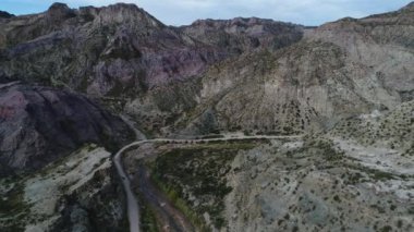 Atuel river canyon San Rafael, Mendoza Cuyo Arjantin hava dron sahne. Hareketli kamera modern yeni 4 x 4 van izleme iletir. Çakıl sokak sonraki ağaçlar ve nehir. Derma kayalar.