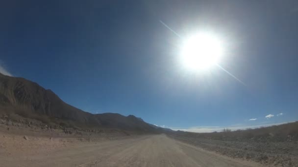 Timelapse 的碎石路在一个非常有风的一天 门多萨 Cuyo 阿根廷 相机向前移动 黑暗的山丘和山脉的两侧 Payun Liso 火山背景 — 图库视频影像