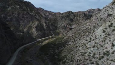 Atuel river canyon San Rafael, Mendoza Cuyo Arjantin hava dron sahne. Kamera hareket büyük kayalara doğru iletir. Caddesi yeşil bitkiler ve Nehri yanındaki çakıl. Derma kayalar.