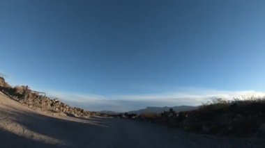 Çakıl yol çok rüzgarlı bir günde Timelapse. Mendoza Cuyo, Arjantin. Kamera hareketli ileri. Yağ extravtion pompaları iki tarafta. Bulutlar gökyüzü üzerinde.