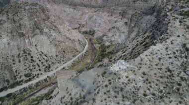 Atuel river canyon San Rafael, Mendoza Cuyo Arjantin hava dron sahne. Kamera hareket iletir. Çakıl sokak sonraki ağaçlar ve nehir. Derma kayalar.