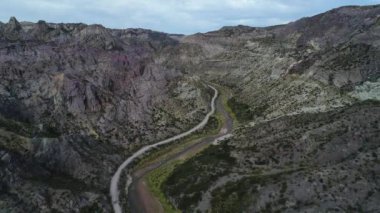 Atuel river canyon San Rafael, Mendoza Cuyo Arjantin hava dron sahne. Yukarı doğru hareket kamera ve modern yeni 4 x 4 van görünür. Çakıl sokak sonraki ağaçlar ve nehir. Derma kayalar.