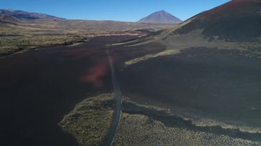 Hava dron sahne La Payunia Milli Parkı Malargue, Mendoza, Arjantin'in. Pampa Negras siyah ile kırmızı zemin volkan kayalar. Altın otlar. Arka plan üzerinde Payun Liso volkan. Çakıl yol