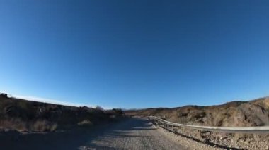 Çakıl yol çok rüzgarlı bir günde Timelapse. Mendoza Cuyo, Arjantin. Kamera hareketli ileri. Yağ extravtion pompaları iki tarafta. Bulutlar gökyüzü üzerinde.