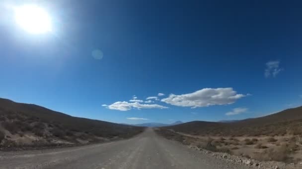 阿根廷 Cuyo 门多萨南部的碎石路 Timelapse 相机向前移动 紧紧抓住汽车 黑暗的山丘和山脉的两侧 天空中的云彩 — 图库视频影像