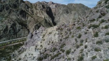 Atuel river canyon San Rafael, Mendoza Cuyo Arjantin hava dron sahne. Geriye doğru hareket kamera ve aşağı büyük kayalar üzerinde. Caddesi yeşil bitkiler ve Nehri yanındaki çakıl. Derma kayalar.