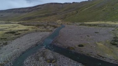 Andes Dağları, Mendoza Cuyo Arjantin hava dron sahne. Patagonya bozkır manzara. Kamera gidiyor tezcan nehrine doğru römork, kamyonet ve karavan ile van üzerinden iletir. Campanario dağın karla arka planda. Bulutlu karanlık gün.