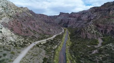 Atuel river canyon San Rafael, Mendoza Cuyo Arjantin hava dron sahne. Hareketli kamera modern yeni 4 x 4 van izleme iletir. Çakıl sokak sonraki ağaçlar ve nehir. Derma kayalar.