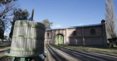 Seyahat ve panning kamera hareket vasıl günbatımı altın saat büyük tuğla inşaat mükemmel. eski vintage ahşap varil. Ağaçlar, yapraklar ve çim. Kiler Mendoza, Arjantin şarap üretimi için.