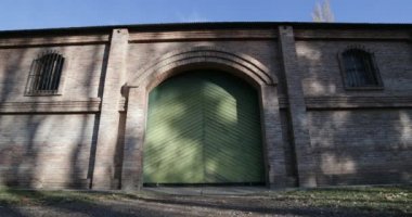 Seyahat ve panning kamera hareket vasıl günbatımı altın saat büyük tuğla inşaat mükemmel. Kameranızın doğru yeşil kapı, kapı. Ağaçlar, yapraklar ve çim. Kiler Mendoza, şarap üretimi için.