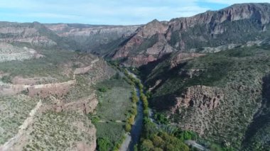 Atuel river canyon San Rafael, Mendoza Cuyo Arjantin hava dron sahne. Fotoğraf makinesi ve yukarı doğru hareket iletir. Willows ağaçlar ve Nehri yanındaki sokak. Derma kayalar.