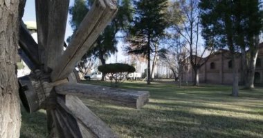 Seyahat ve panning kamera hareket vasıl günbatımı altın saat büyük tuğla inşaat mükemmel. Eski ahşap vintage sepeti Vagon tekerlek. Ağaçlar, yapraklar ve çim. Kiler Mendoza, Arjantin şarap üretimi için.