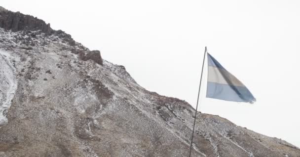 阿根廷风化旗流动和移动在一个刮风的灰色多云天与山与雪在 Bakground 门多萨 阿根廷 — 图库视频影像