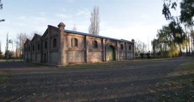 Stabilize kamera hareket büyük tuğla inşaat vasıl günbatımı altın saat. Yeşil kapı, büyük kapı ile bina doğru hızlı hareket kamera. Kiler Mendoza, Arjantin şarap üretimi için.