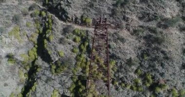 Cable Car Chilecito - La Mejicana altın madeni havadan dron sahne. Famatina dağların ortasında uzun boylu kuleye genel bakış. Kamera senital biter inşaat yan görünümü ile başlar..