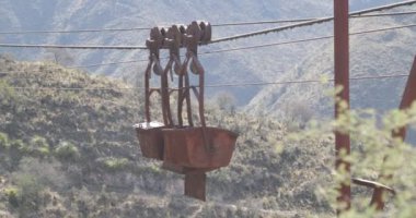 Eski teleferik Chilecito-La Mejicana benim. Ayrıntı vagonlar kablo üzerinden asılı. Dağlar ve rüzgar gibi hareketli arka plan, bitki örtüsü. Kamera hala kalır. Ulusal endüstriyel miras