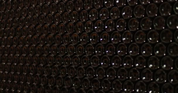 多くのボトルでワイン貯蔵積み上げ他上の つです 暗いガラスの瓶の下のテクスチャ 飲料業界の詳細 フィールドの浅い深さでゆっくり旅カメラ — ストック動画