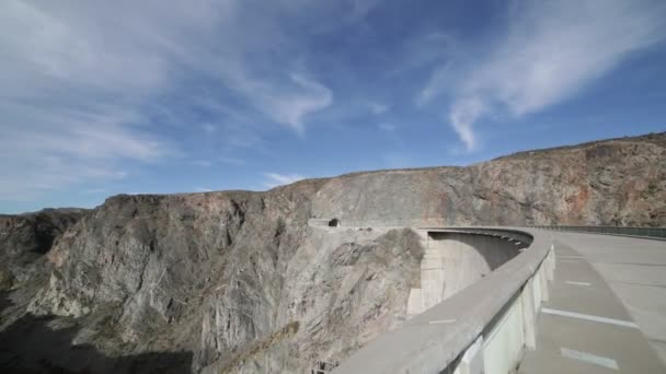 手持ちカメラ通りとアグア ・ デ ・ トロ ダムの歩道を歩きます。右とトンネルと岩の崖の背景に川の渓谷。サン ・ ラファエル、アルゼンチンのメンドーサ. — ストック動画