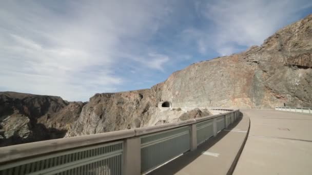 Hand-het gehouden camera lopen door de straat en stoep van Agua de Toro Dam naar tunnel. Achtergrond van de rotsachtige klippen van het dal van rivier. San Rafael, Mendoza, Argentinië. — Stockvideo