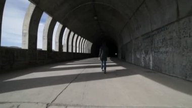 Doğru yürüyüş ve brutalist beton tünelde getting kamera kadın elini tuttum. Işıklar ve gölgeler windows, açıklıklar, tünel içinde tarafından yapılan rithms. Sokak infraestructure. Arjantin, Mendoza