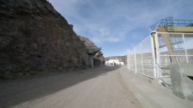 El sahne Agua de Toro barajda San Rafael, Mendoza Cuyo Arjantin için çakıl yol yaklaşıyor. Yol boyunca metal ve beton yapılar.